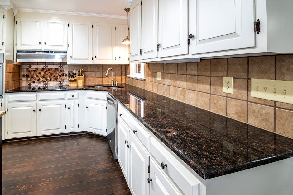 Tiled kitchen backsplash with grout lines, white cabinets and granite countertops in a Boise home