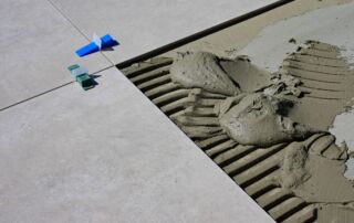 Close-up of tile grout lines during floor installation, highlighting the importance of proper grout sealing.