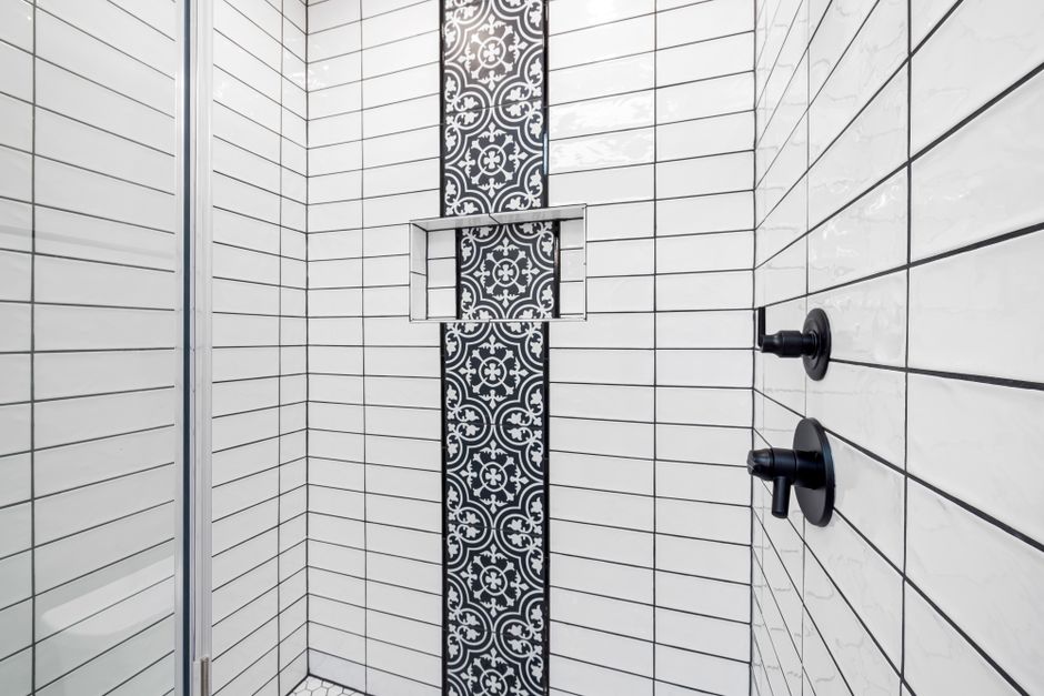 Close-up of tiled shower wall with grout lines between ceramic tiles